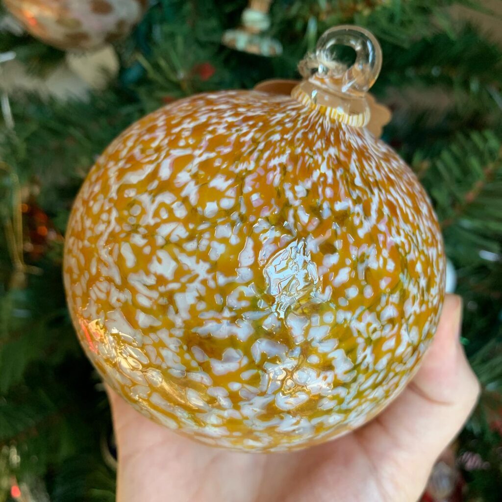 A person holding an ornament in their hand.