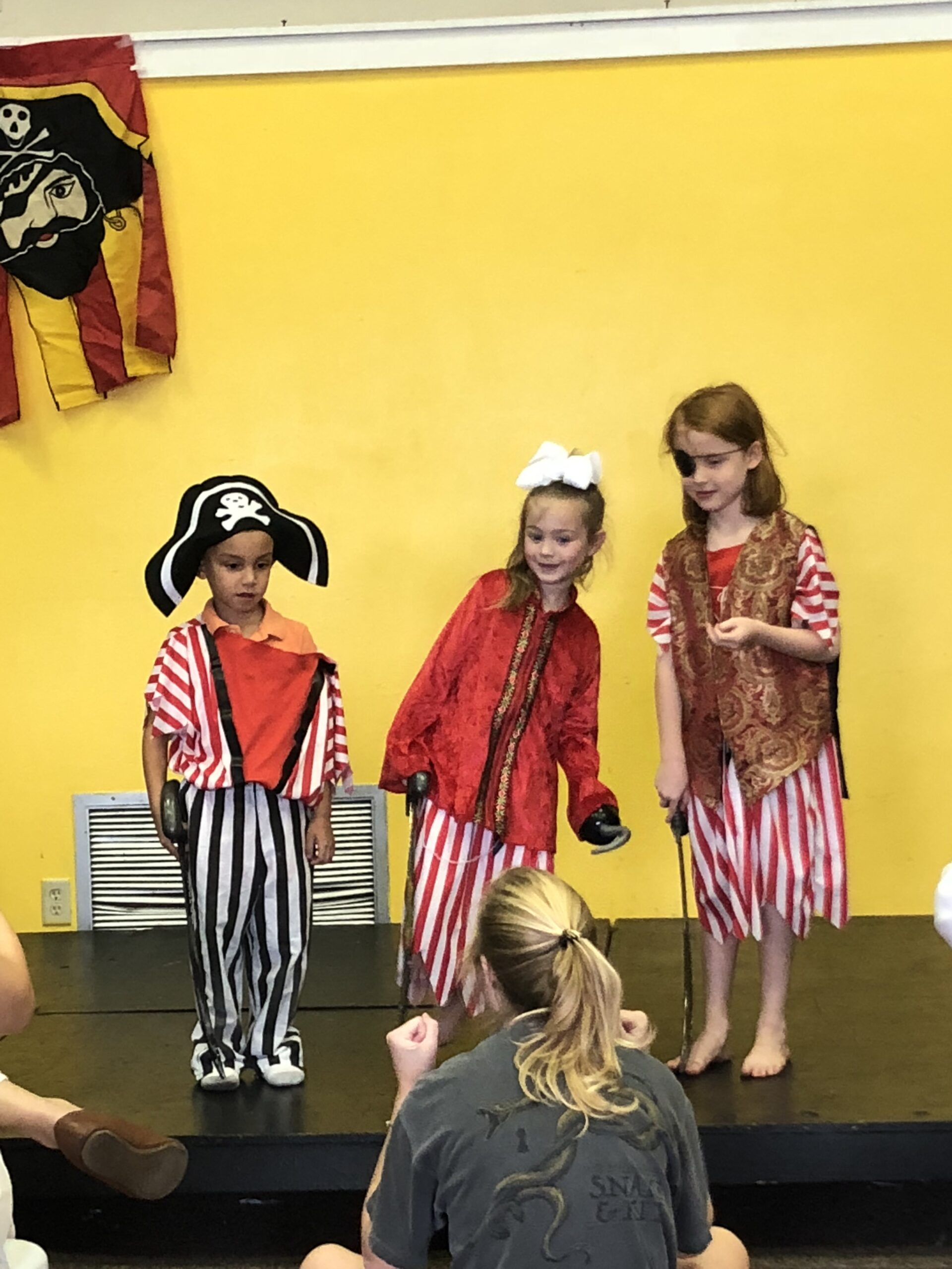 Three children dressed as pirates perform a skit.