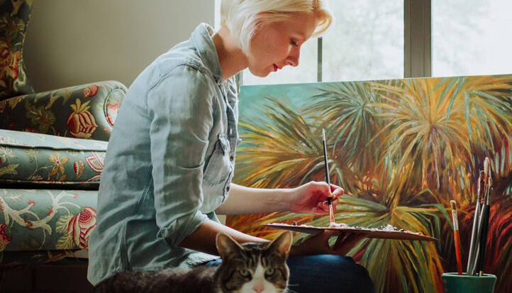 A woman sitting on the floor with her cat.