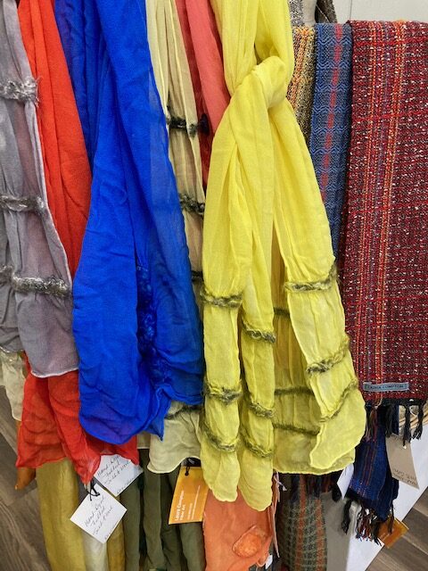 A bunch of different colored dresses hanging up