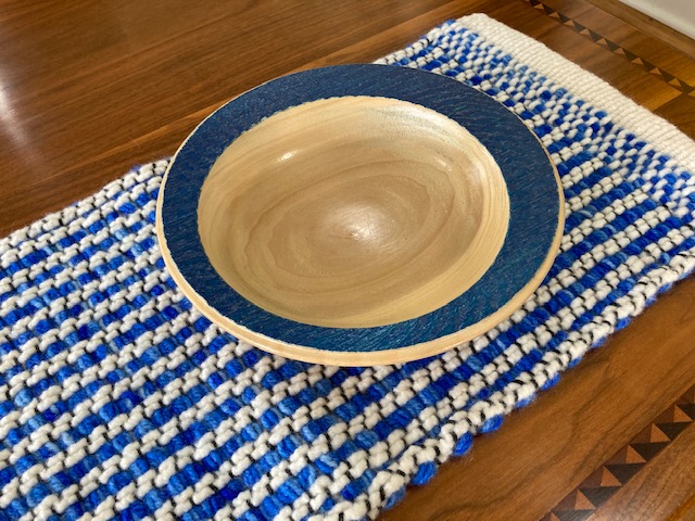 A bowl sitting on top of a blue and white table.