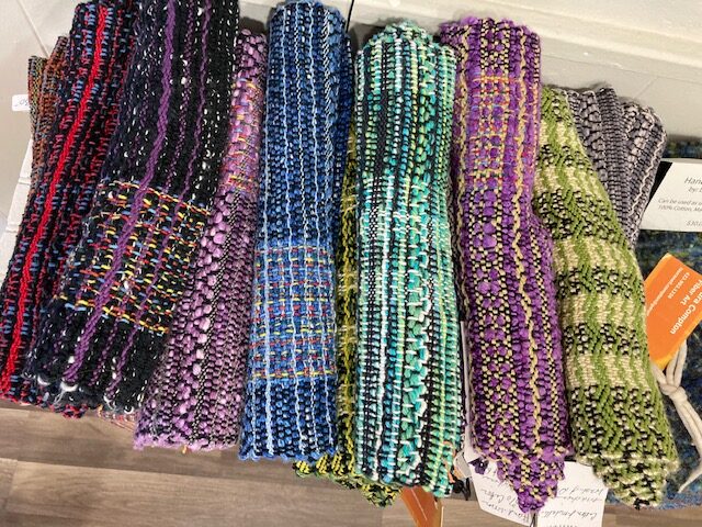 A bunch of different colored scarves on display