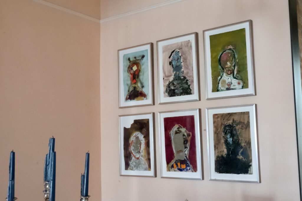 A wall with six framed pictures of people.