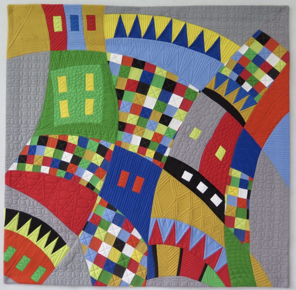 A colorful quilt with many different shapes and colors.