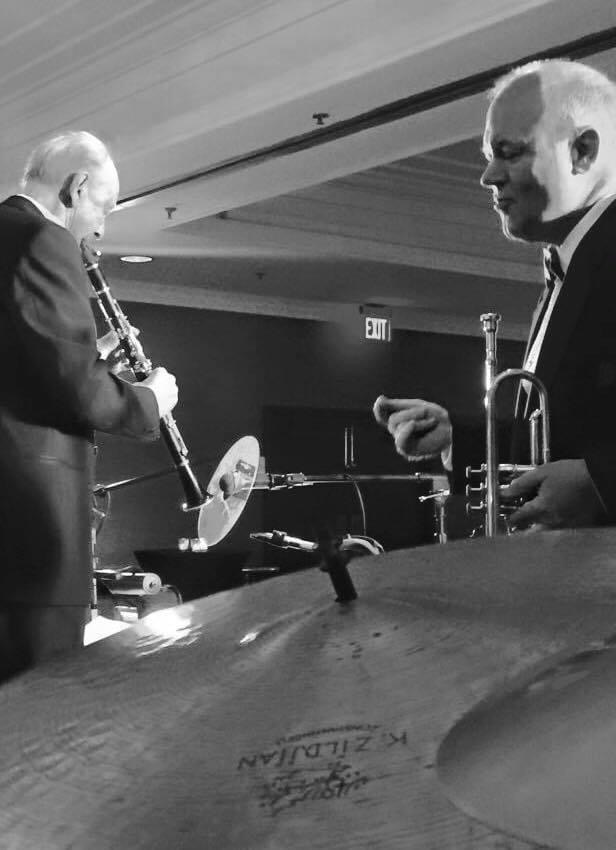 Two men playing musical instruments in a room.