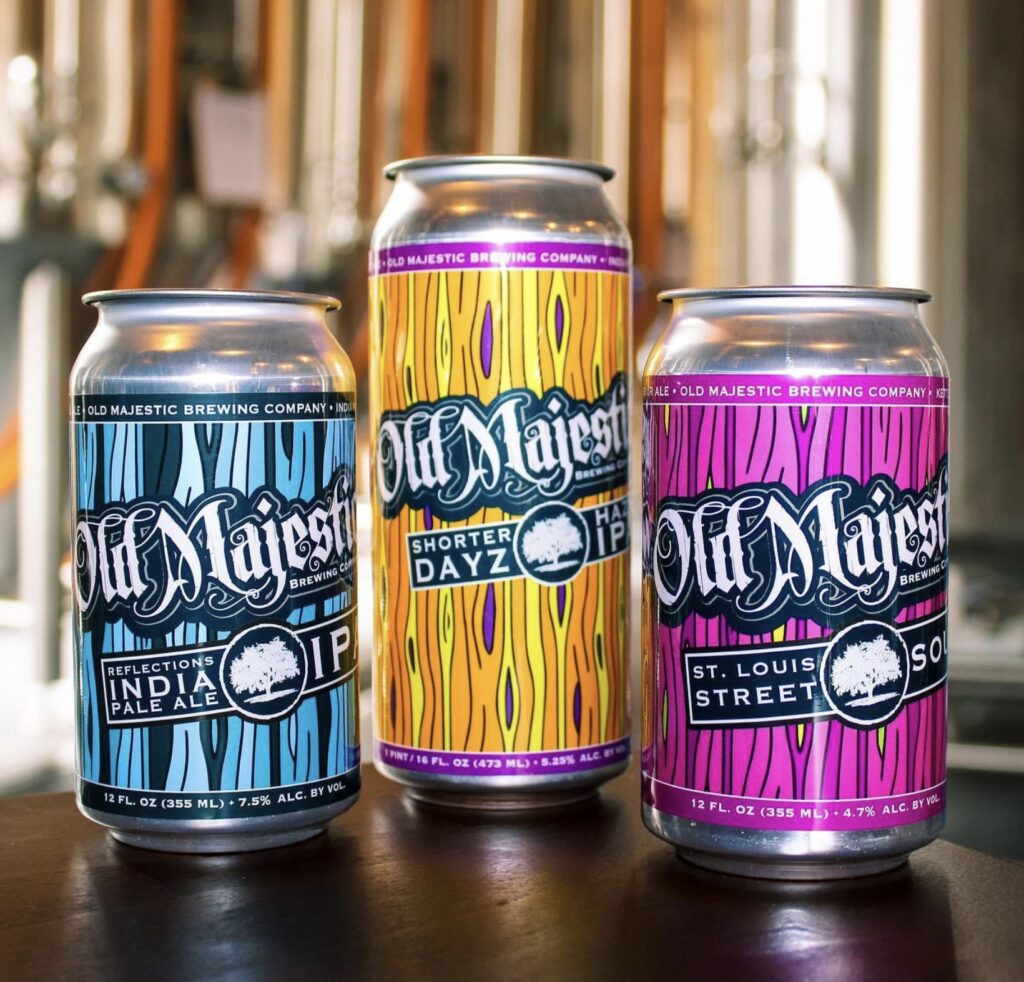 Three cans of old majesty beer on a table.