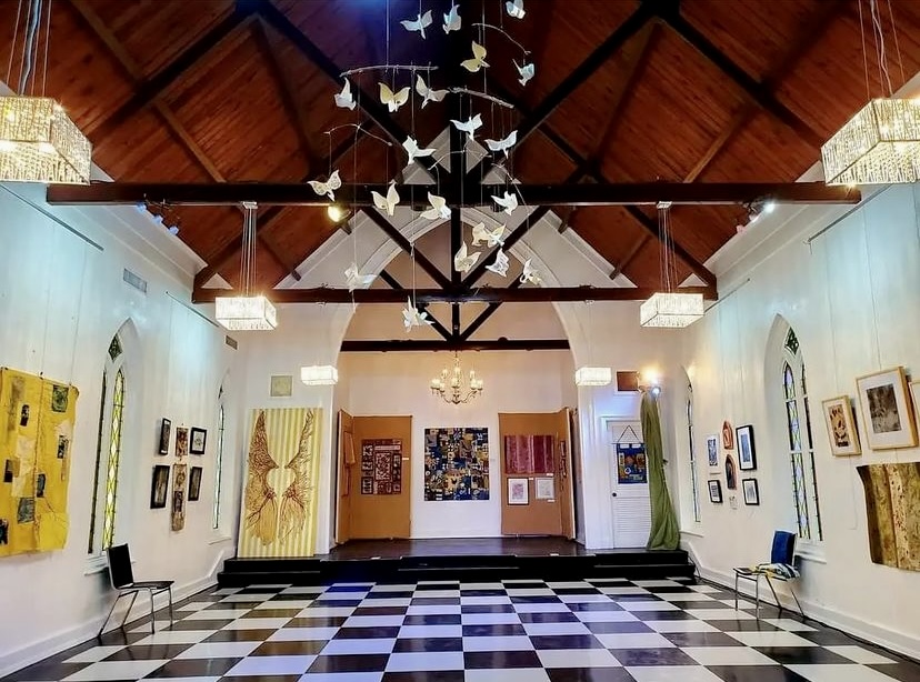 A room with checkered floors and a ceiling decorated with paper cranes.