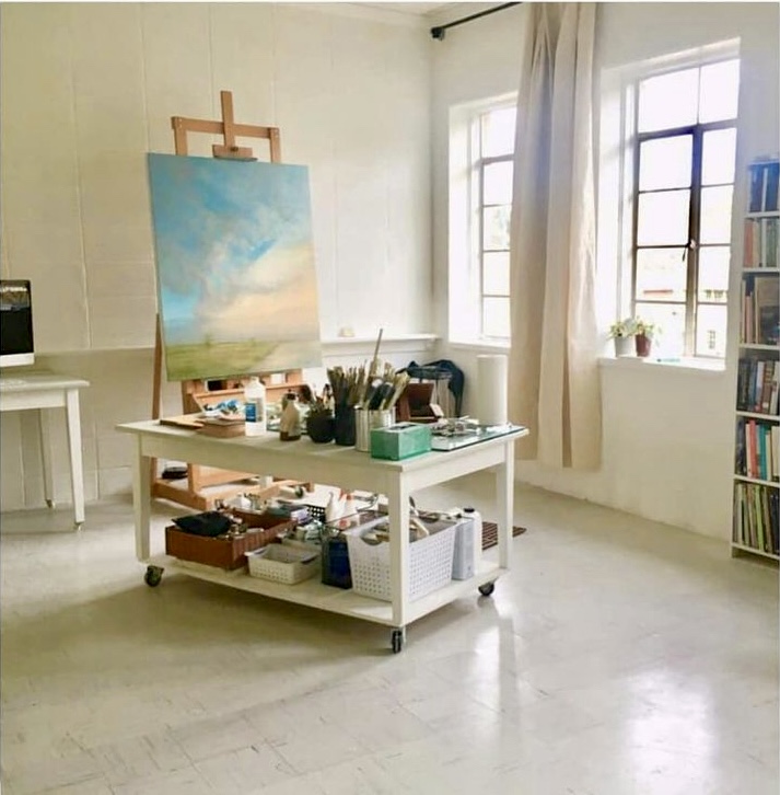 A room with a table and some paintings on it