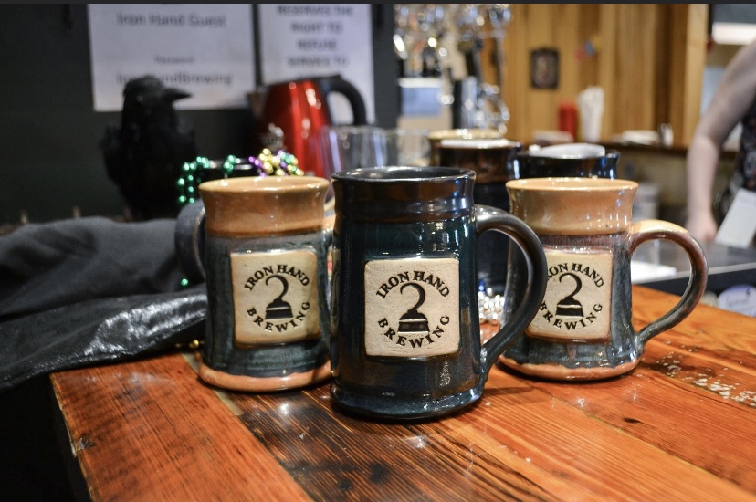 A couple of mugs sitting on top of a wooden table.