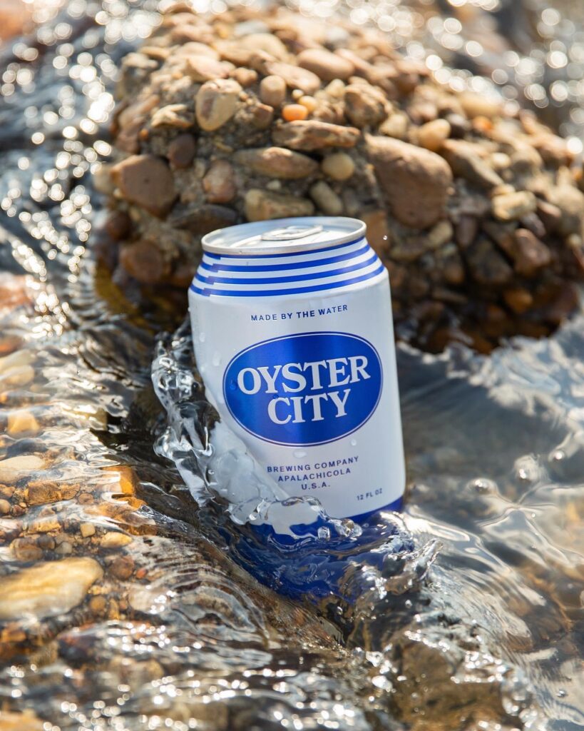 A can of beer is sitting in the water.