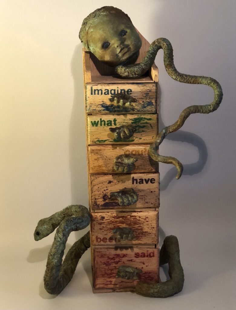 A sculpture of snakes and a snake on top of a stack.