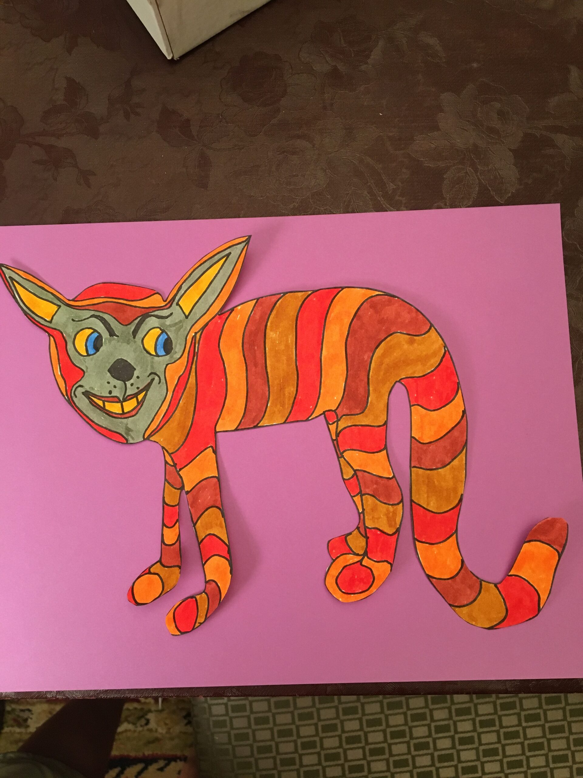 A cat is made out of paper and has been colored.