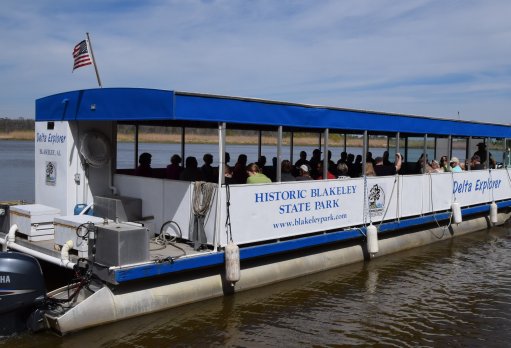 A boat with people on it is going down the river.