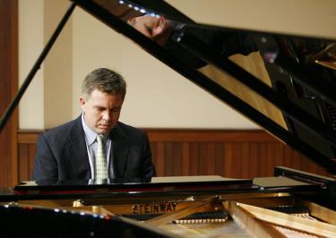 A man sitting at the piano playing an instrument.