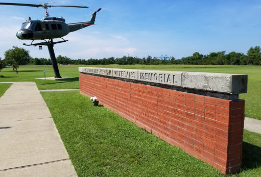 A helicopter is flying over the wall of an airport.