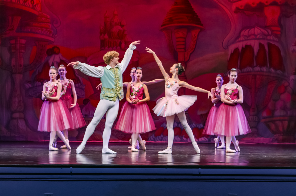 A group of young ballerinas performing on stage.