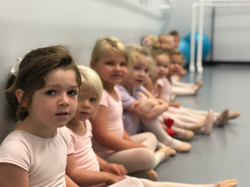 A group of young children sitting in line.